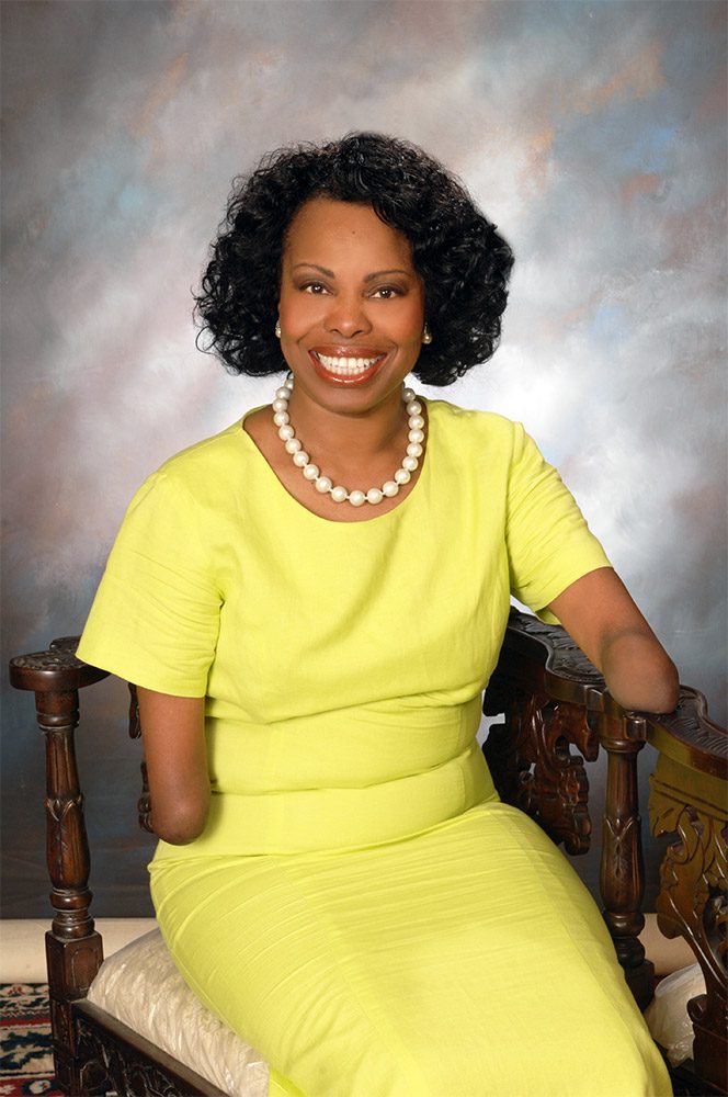 A woman in yellow dress sitting on chair.