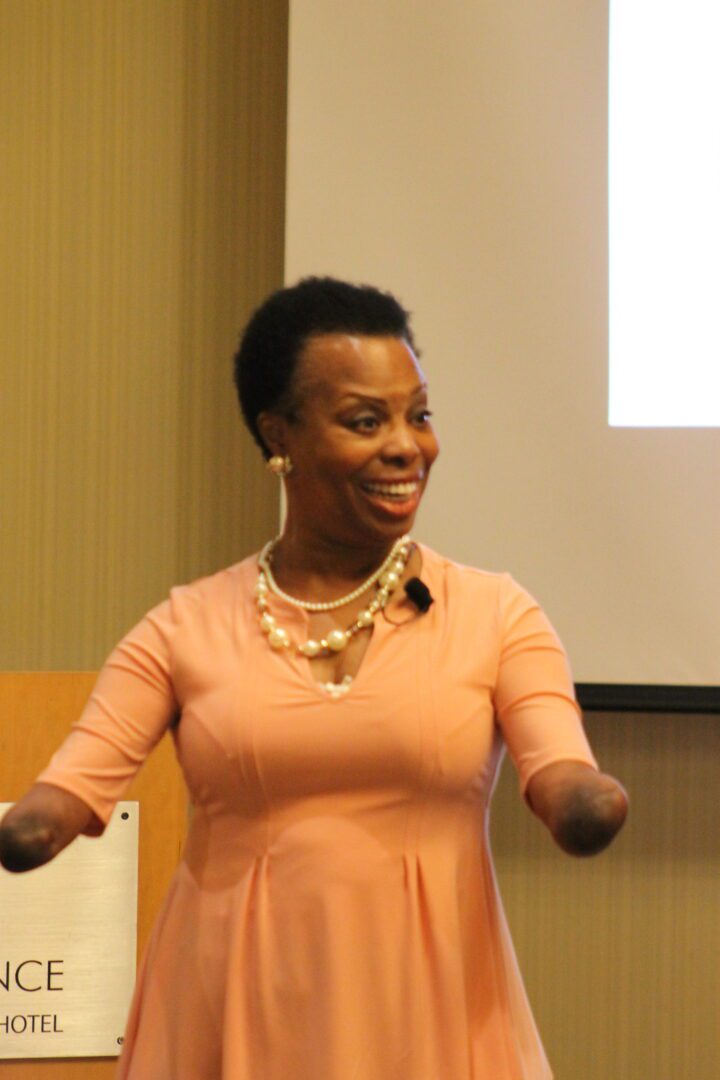 A woman in an orange dress is holding her hands up